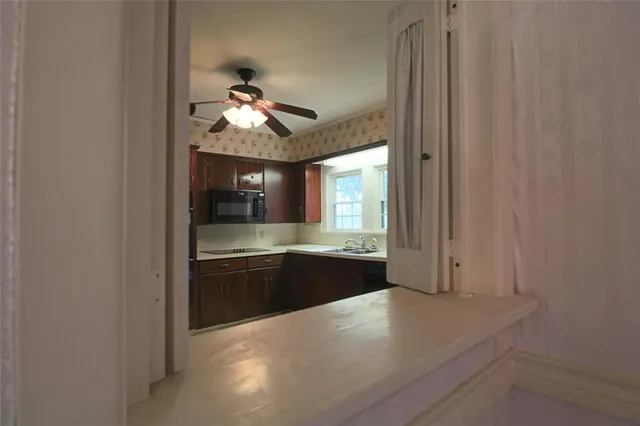 a large kitchen with a sink and refrigerator