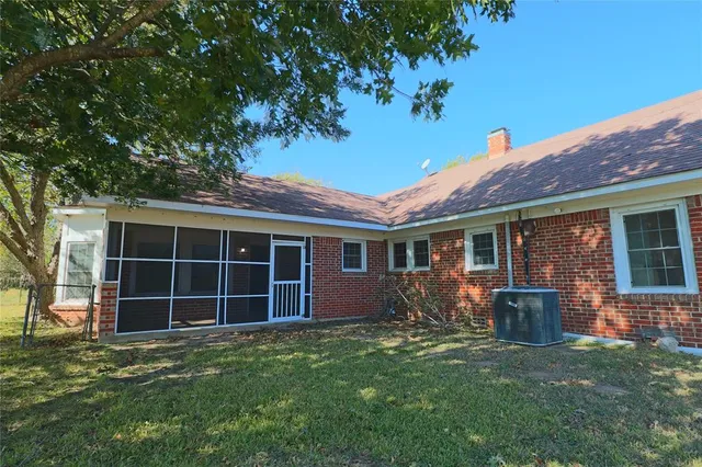 a backyard of a house with large trees and plants