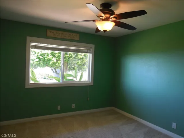 an empty room with a window and a fan