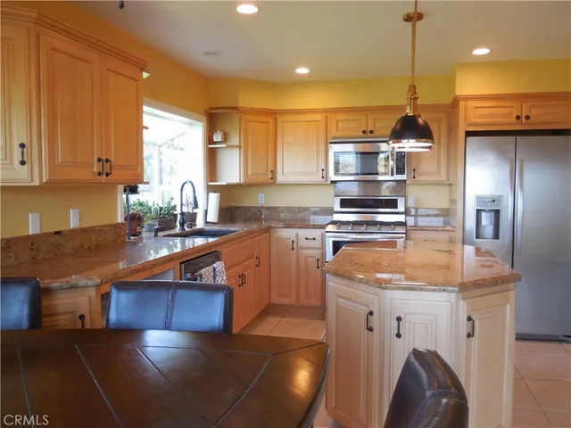 a kitchen with stainless steel appliances granite countertop a sink a stove and a refrigerator