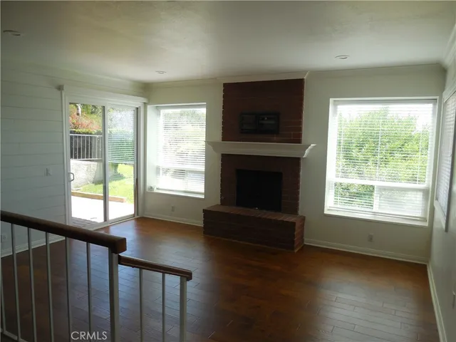a view of a livingroom with furniture a fireplace and wooden floor