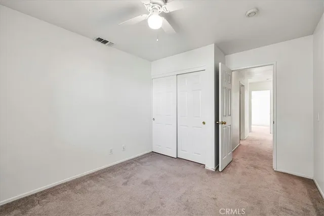 an empty room with a ceiling fan and a window