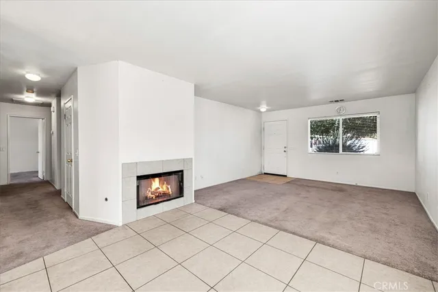 an empty room with windows and fireplace