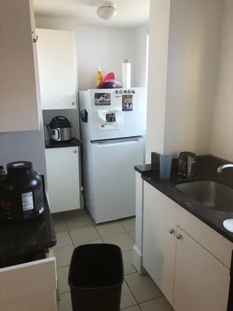 a kitchen with a refrigerator and a stove top oven