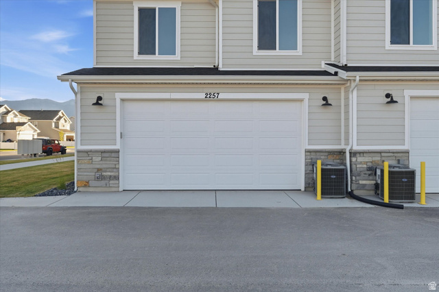 2257 South 1090 West, Unit 74 Nibley, UT 84321 - Photo 27 of 40 Property exterior featuring light gray horizontal siding and a white garage door