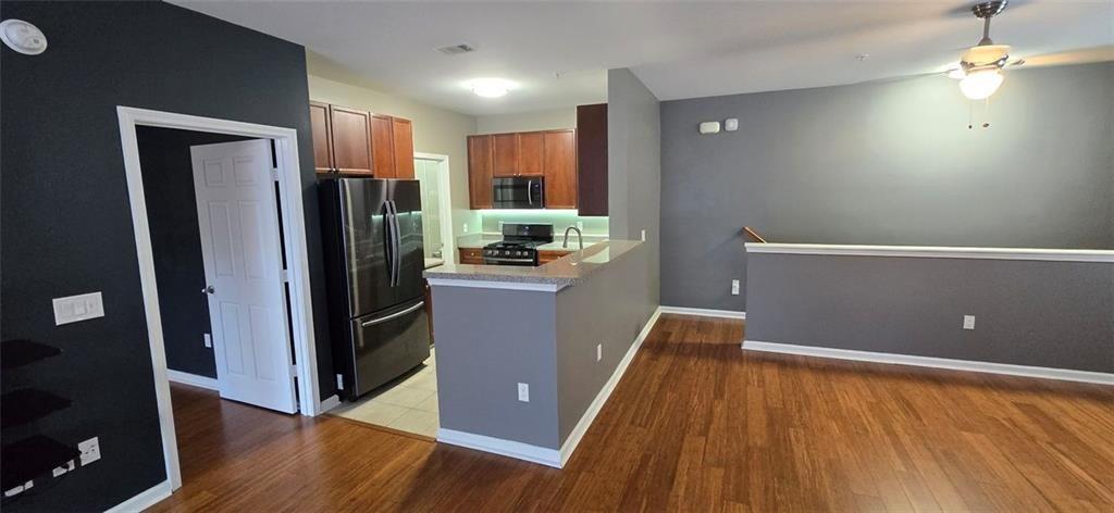 3500 Sweetwater Road, Unit 225 Duluth, GA 30096 - Photo 18 of 34 a kitchen with kitchen island a counter top space wooden floor and a refrigerator