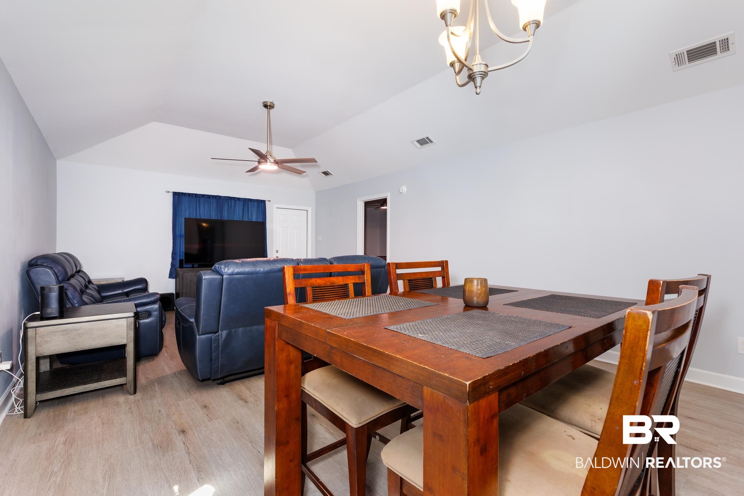 16227 Zenith Drive Loxley, AL 36551 - Photo 10 of 23 Dining room with vaulted ceiling, light wood-type flooring, a chandelier, and a ceiling fan