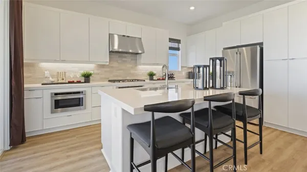 a kitchen with a dining table chairs and refrigerator
