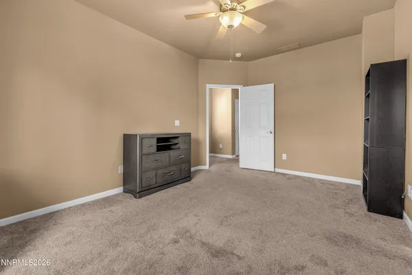 a view of an empty room with a ceiling fan