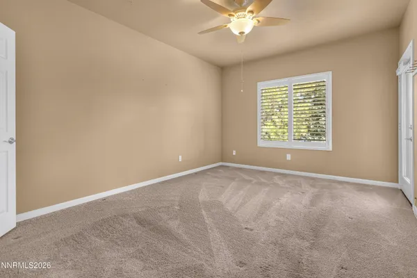 a view of an empty room and a chandelier fan