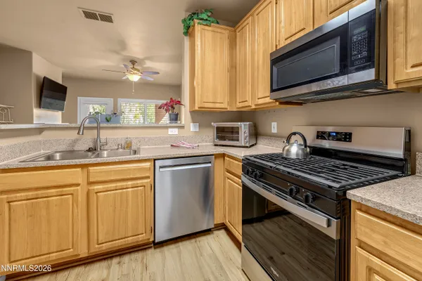 a kitchen with granite countertop a sink stainless steel appliances and cabinets