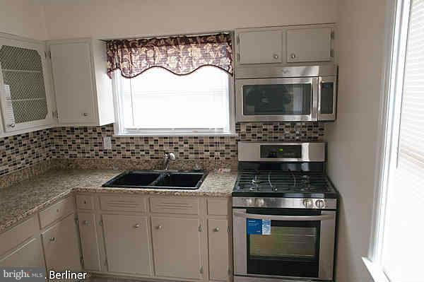 8121 Old Philadelphia Road Baltimore, MD 21237 - Photo 1 of 22 a kitchen with a stove a sink and a microwave