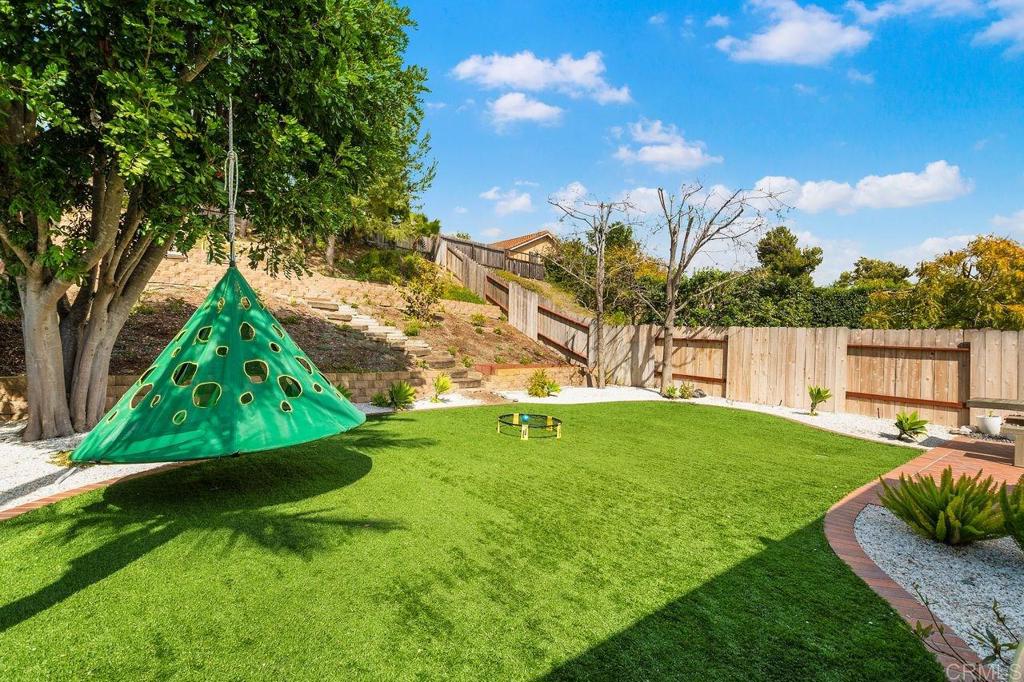 1736 Hill Top Lane Encinitas, CA 92024 - Photo 18 of 41 a view of backyard with table and chairs and a large tree
