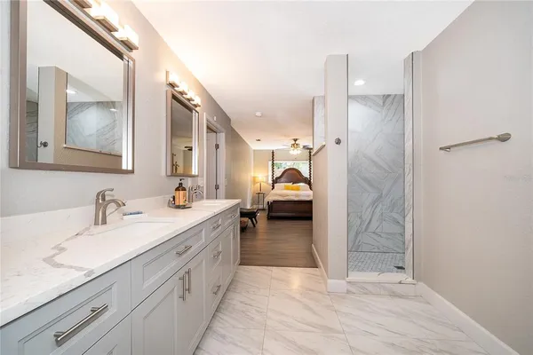 a en suite bathroom with a double vanity sink and a mirror