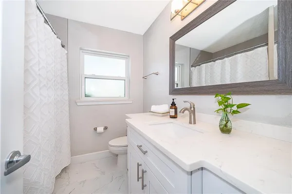 a bathroom with a sink a toilet and a mirror