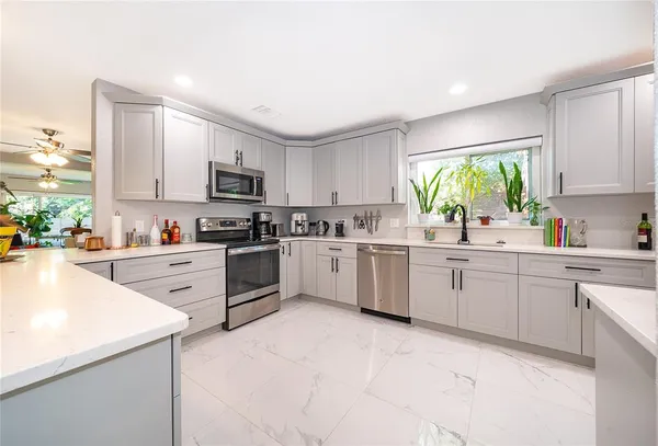 a kitchen with granite countertop white cabinets and white appliances