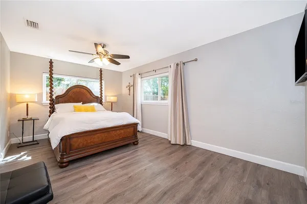 a bedroom with a bed ceiling fan and a window