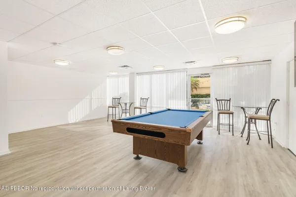 a room with pool table and windows