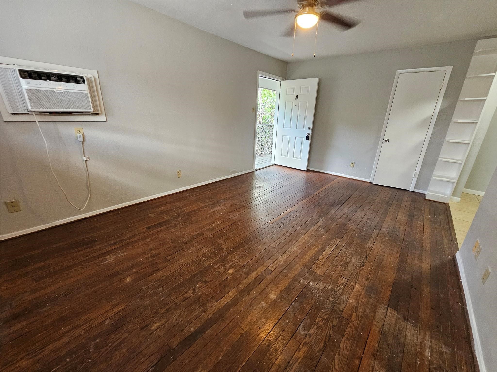 1806 West Main Street, Unit 8 Houston, TX 77098 - Photo 3 of 7 an empty room with wooden floor and windows