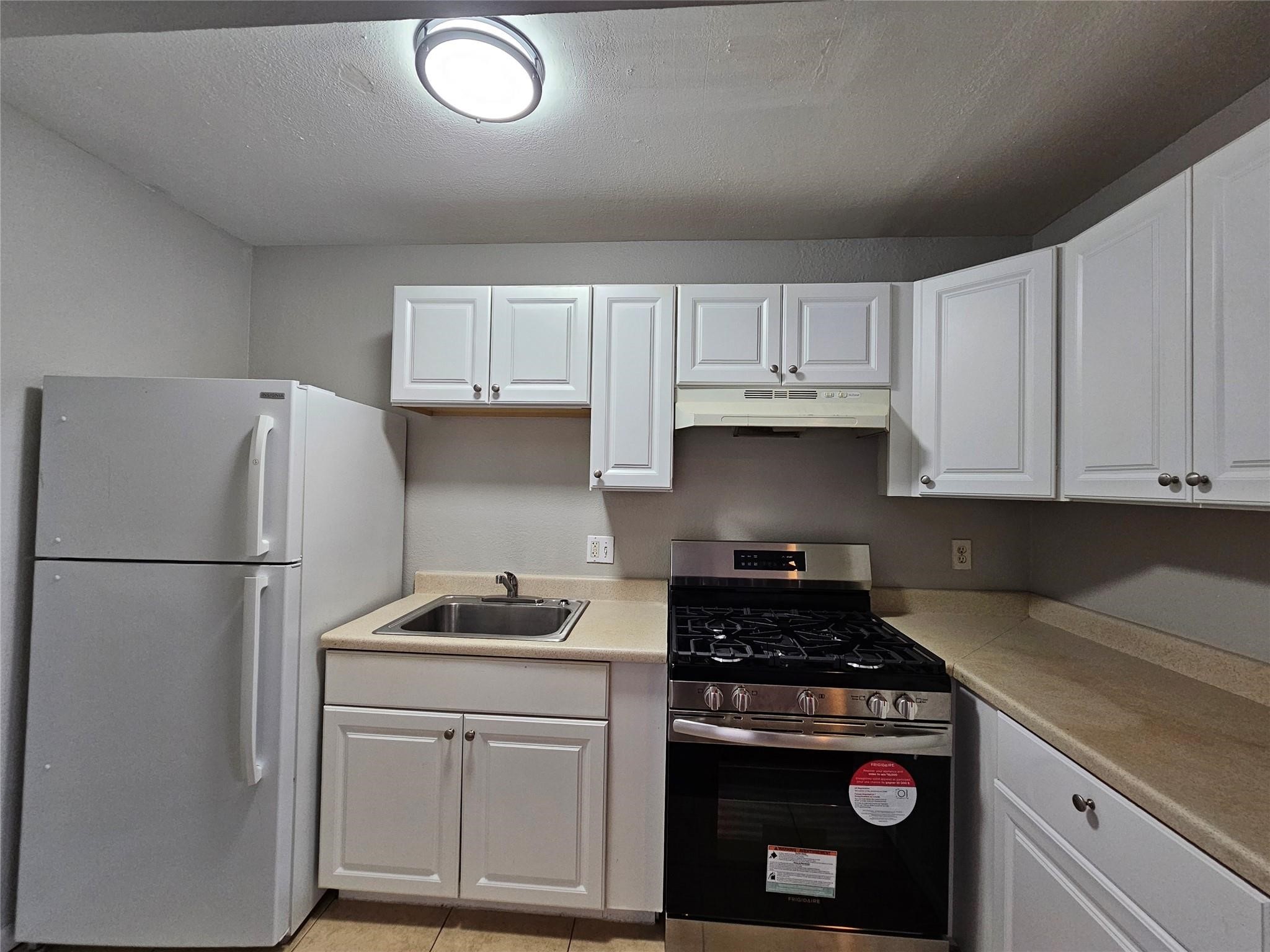 1806 West Main Street, Unit 8 Houston, TX 77098 - Photo 5 of 7 a kitchen with a refrigerator stove and white cabinets