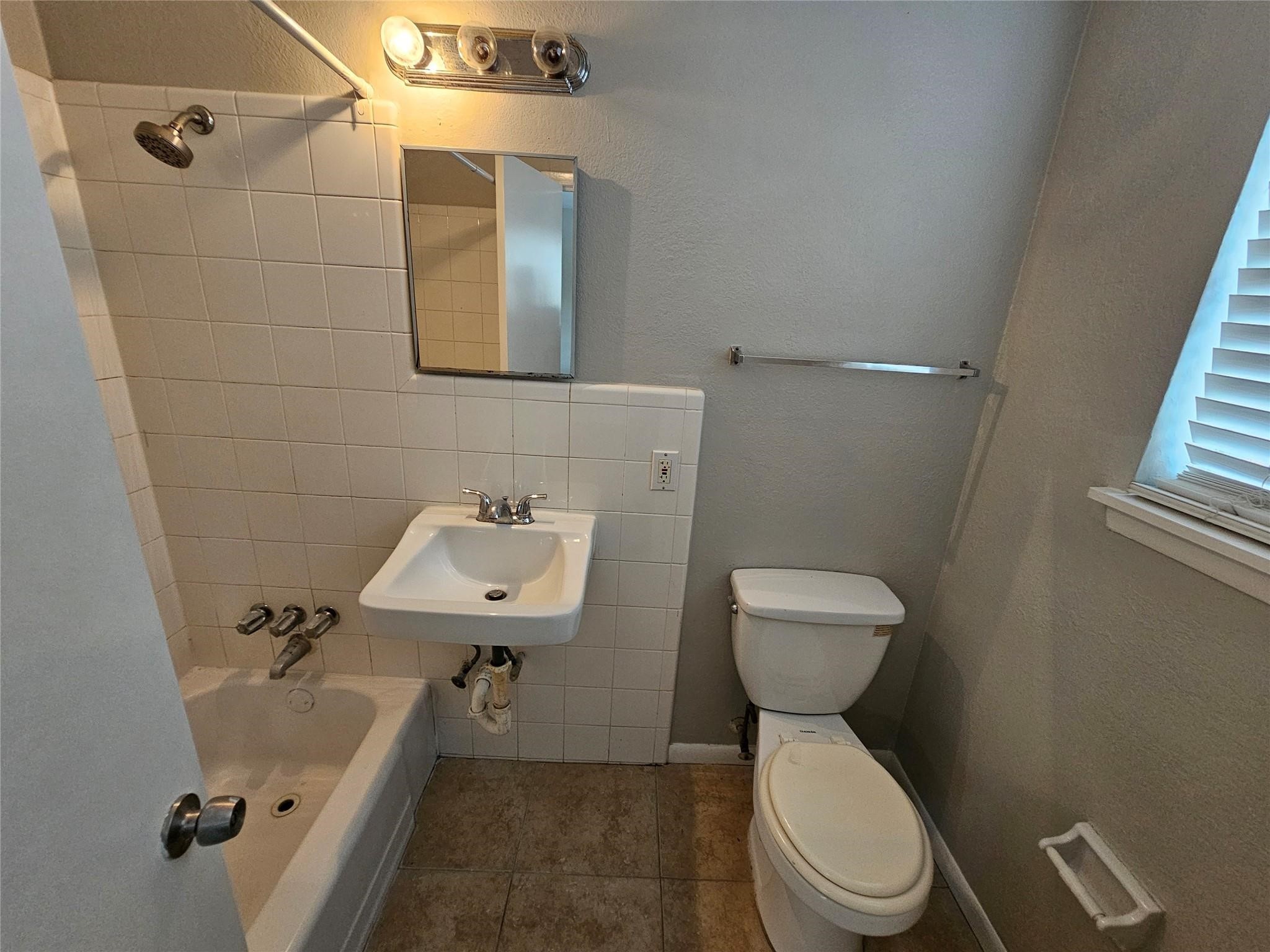 1806 West Main Street, Unit 8 Houston, TX 77098 - Photo 6 of 7 a bathroom with a sink a toilet and a mirror