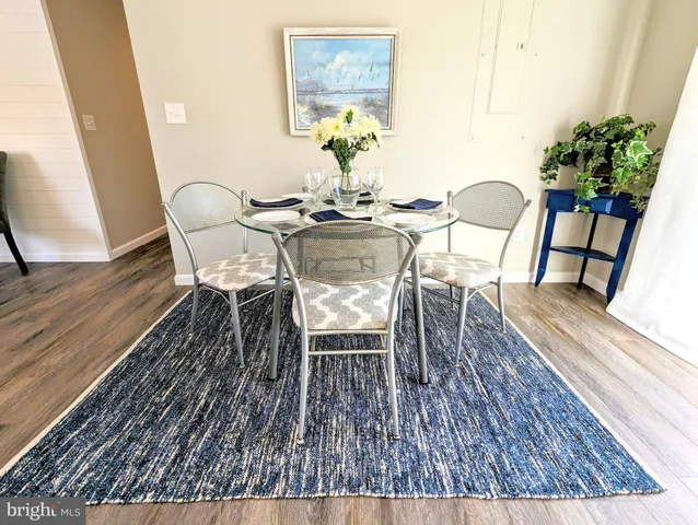 a dining room with furniture potted plants and wooden floor