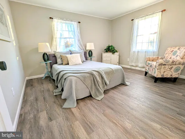 a spacious bedroom with a bed and wooden floor