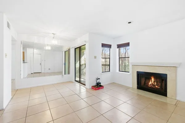 a view of an empty room with a fireplace and a window