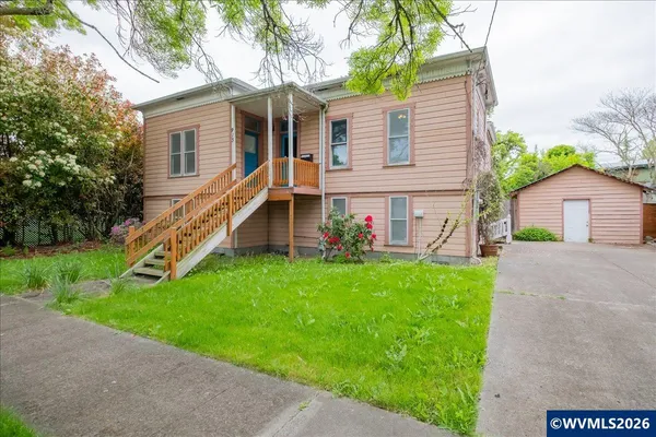 a view of a house with a backyard and a tree