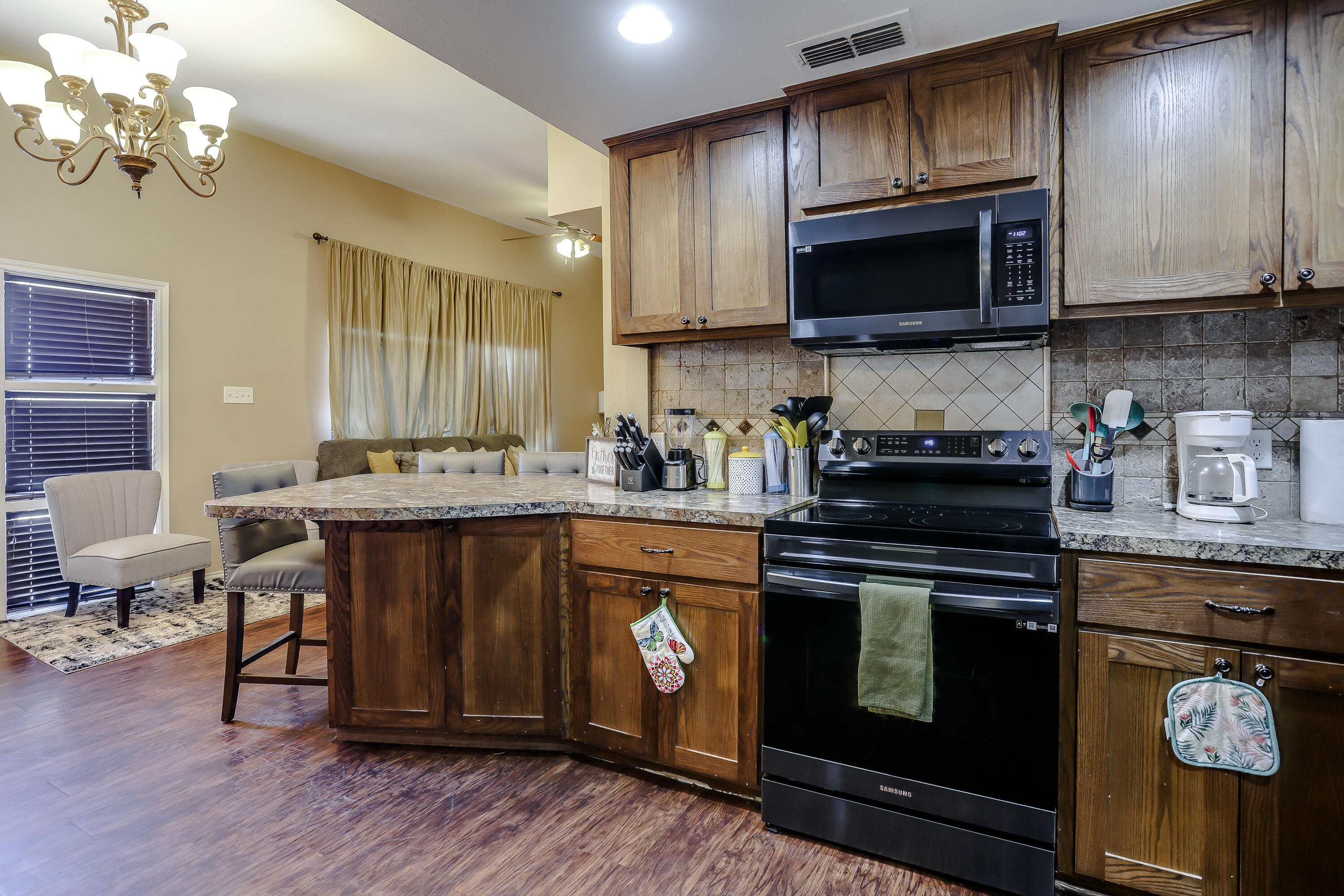 68 Pony Express Trail Lubbock, TX 79404 - Photo 9 of 15 a kitchen with stainless steel appliances granite countertop a stove a sink dishwasher and a microwave oven with wooden floor