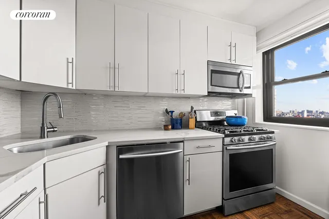 a kitchen with white cabinets stainless steel appliances and sink