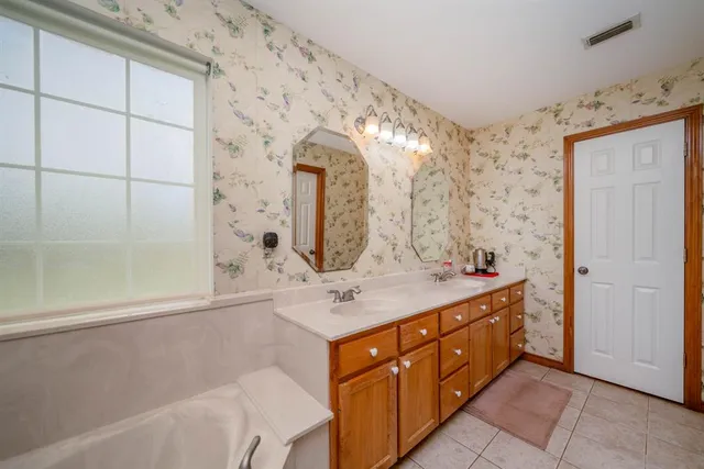 a bathroom with a double vanity sink mirror and shower