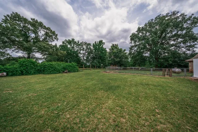 a view of a green field with wooden fence