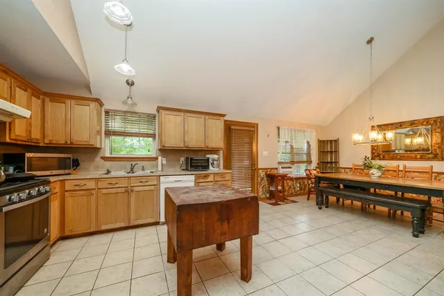 a kitchen with stainless steel appliances granite countertop table chairs sink and cabinets