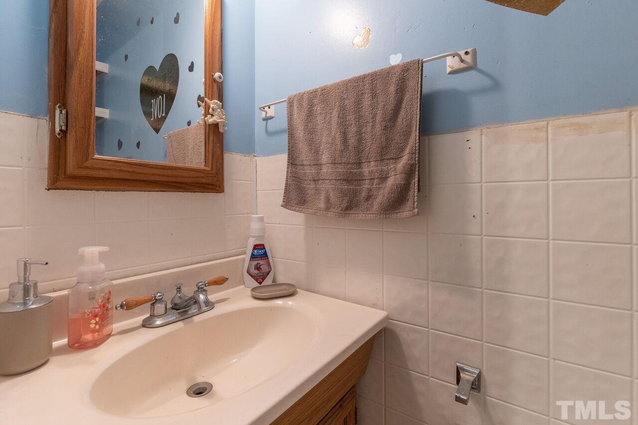 680 Haywood Bailey Road Roxboro, NC 27574 - Photo 14 of 29 a bathroom with a sink mirror and vanity
