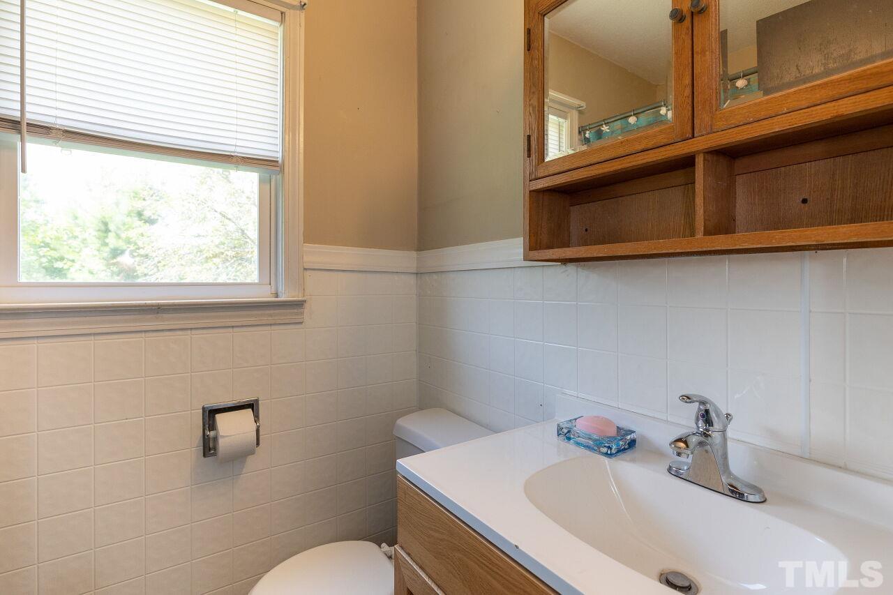 680 Haywood Bailey Road Roxboro, NC 27574 - Photo 20 of 29 a bathroom with a sink a toilet and a mirror