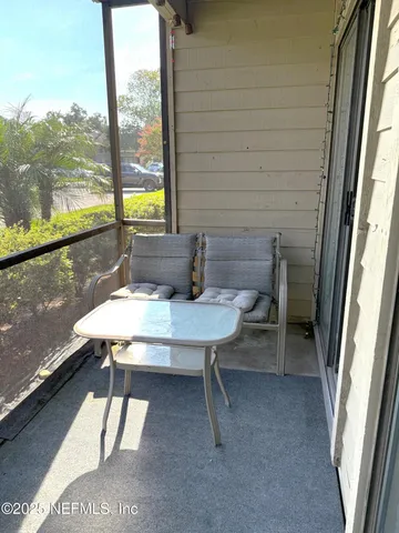 a view of a balcony with table and chairs and wooden floor