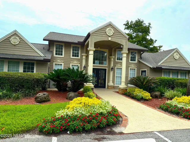 a front view of a house with a yard and potted plants