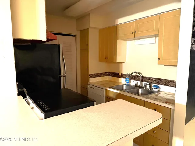 a kitchen with a sink and a refrigerator