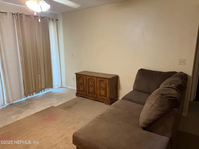 a living room with furniture and a curtain