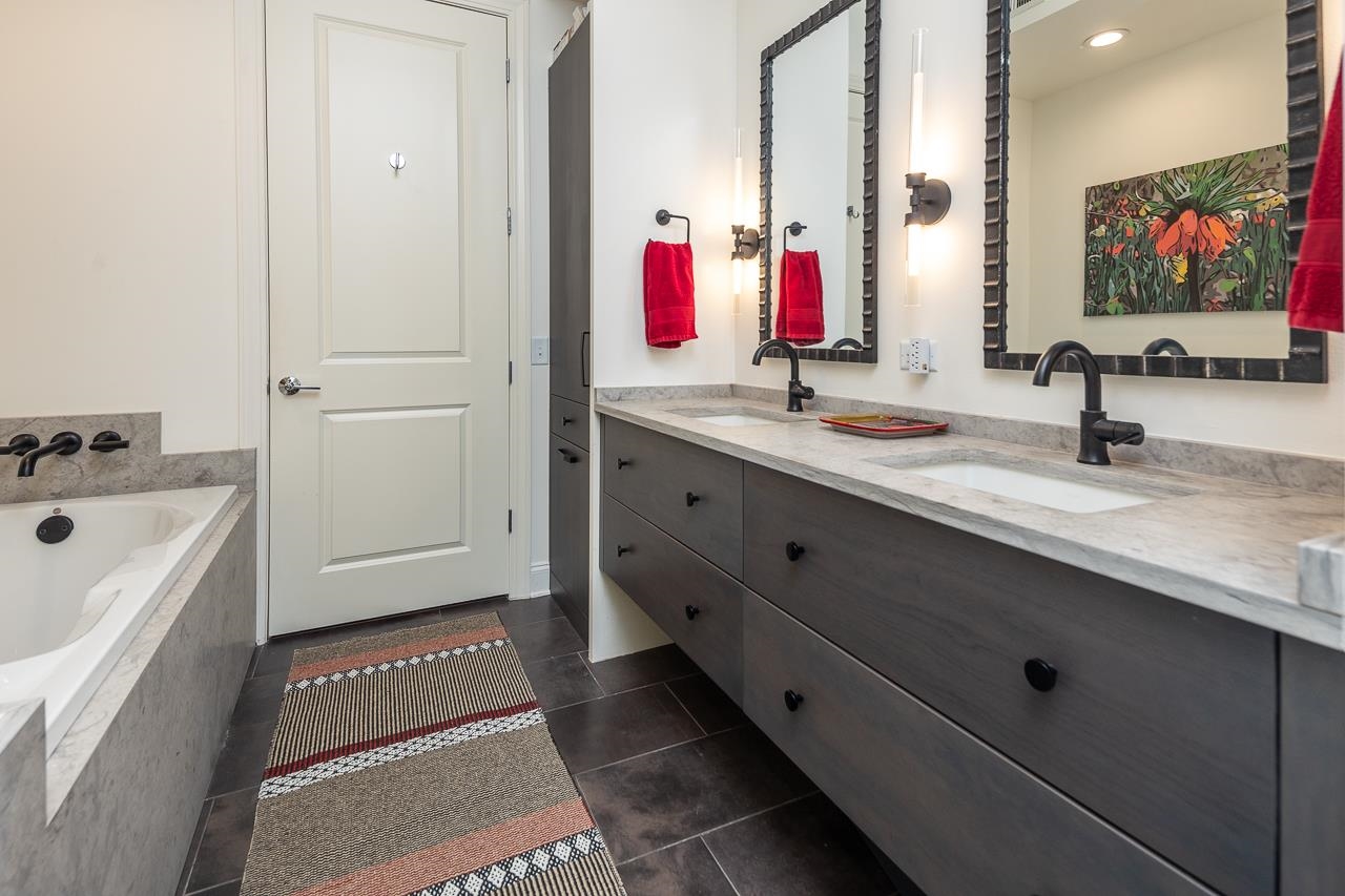 717 Riverside Drive, Unit 109 Memphis, TN 38103 - Photo 16 of 40 Custom Primary bath with updated separate tub and shower, floating custom cabinetry, enhanced lighting, new toilet, sinks and bath fixtures.