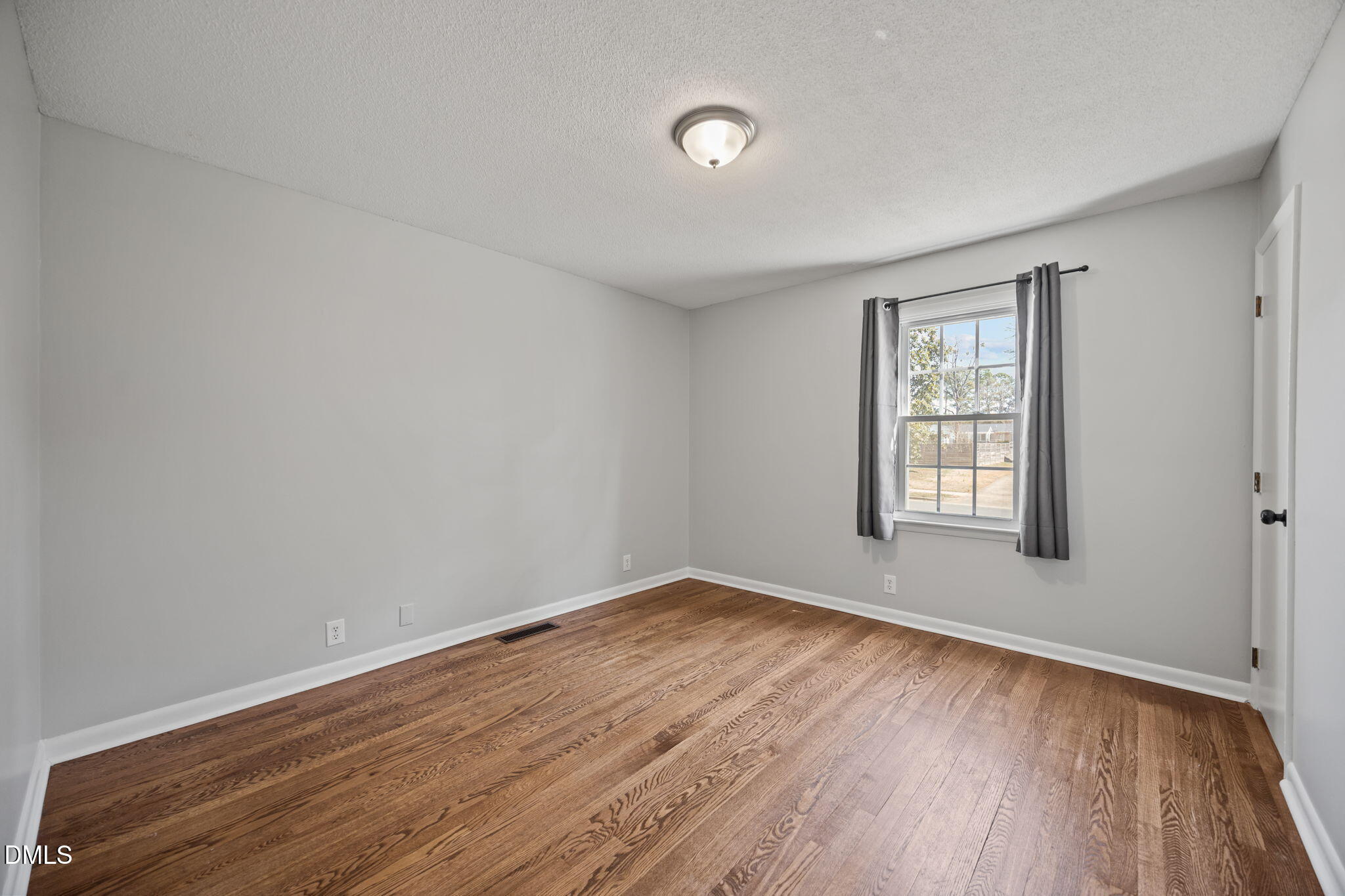 3521 Huntleigh Drive Raleigh, NC 27604 - Photo 22 of 56 an empty room with wooden floor and windows