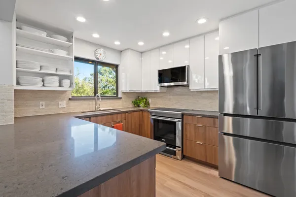 a kitchen with stainless steel appliances a refrigerator sink and microwave