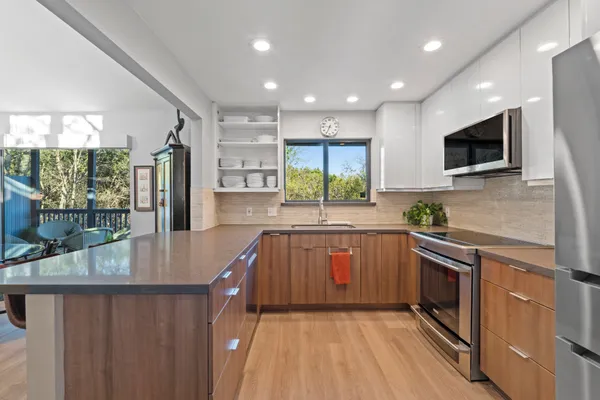 a kitchen with stainless steel appliances granite countertop a stove a sink and a microwave