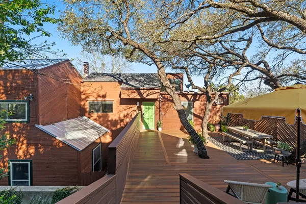 a view of a roof deck with couches and wooden fence