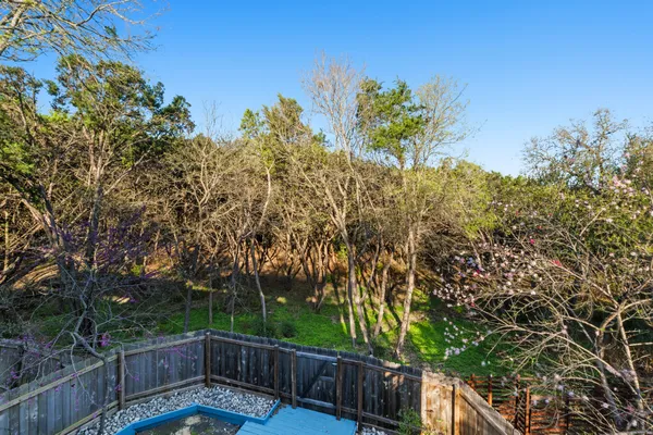 a view of a yard with plants and wooden fence