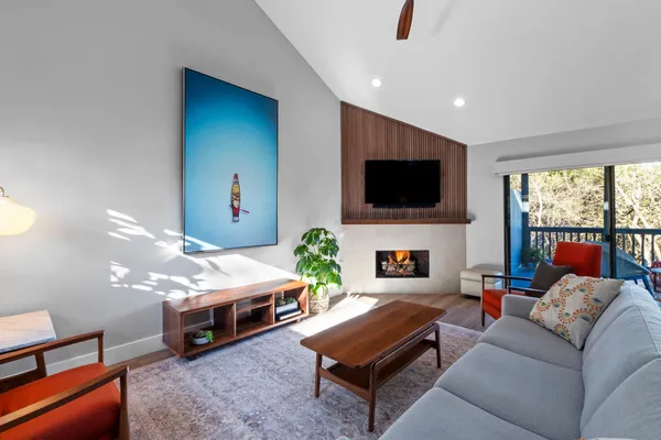 a living room with furniture a fireplace and a flat screen tv