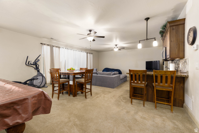 2005 West 450 S Circle St. George, UT 84770 - Photo 23 of 57 Spacious open-concept room featuring neutral carpet flooring, multiple ceiling fans, and a window wall with light-filtering curtains