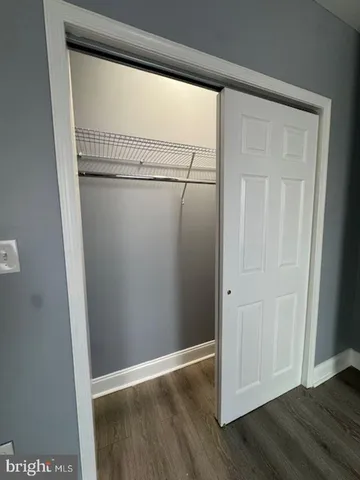 an empty room with wooden floor ceiling fan and windows