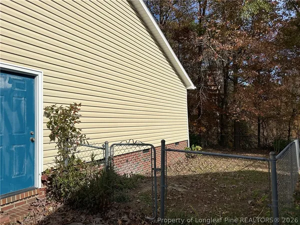 a view of a house with backyard and trees
